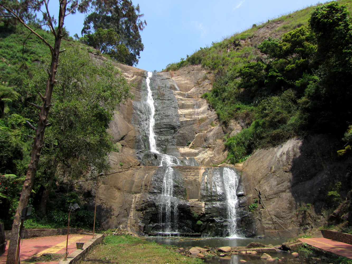 A tall waterfall with a stream of water cascanding down its rocks