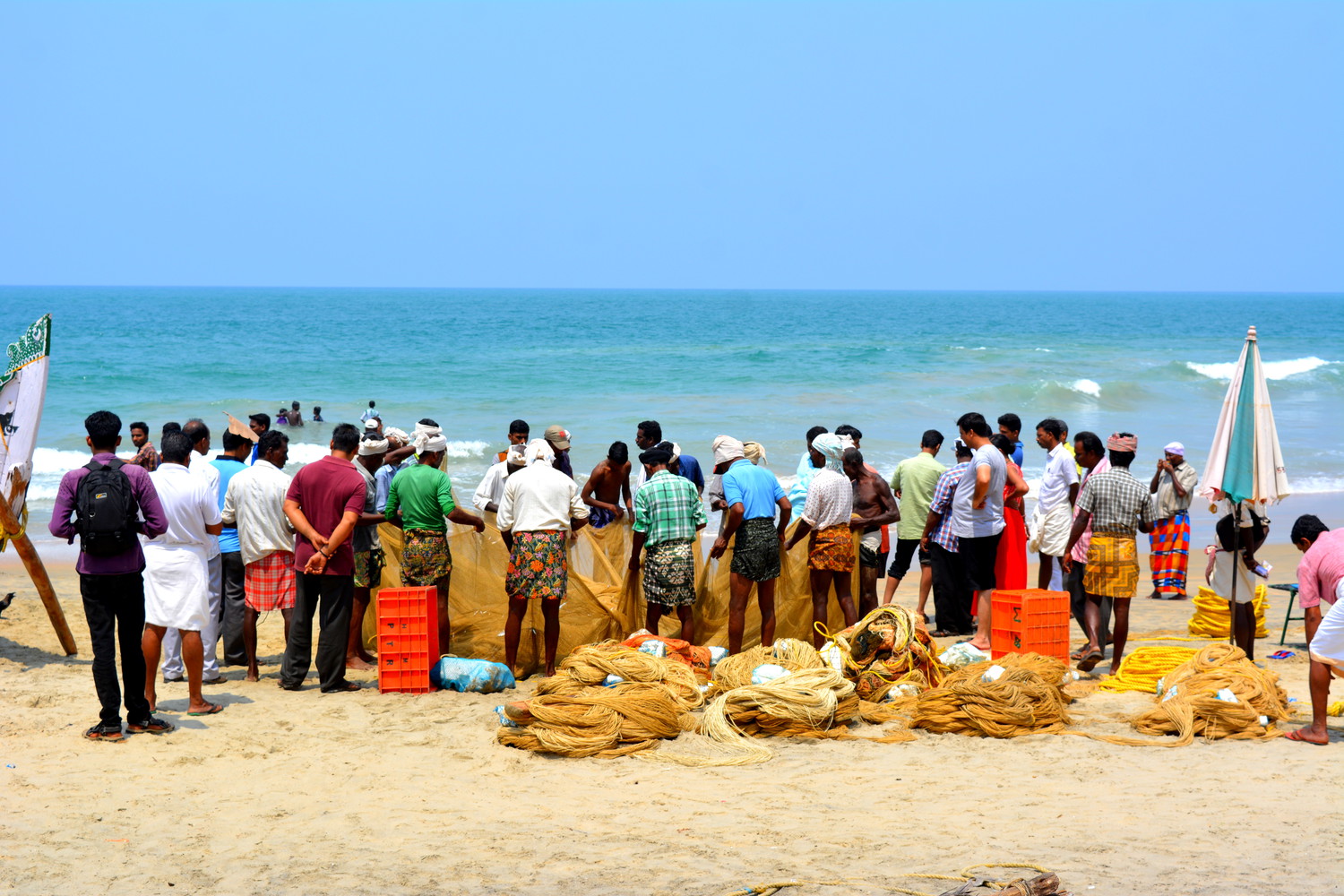 Fishermen holding a large net together at a sea beach