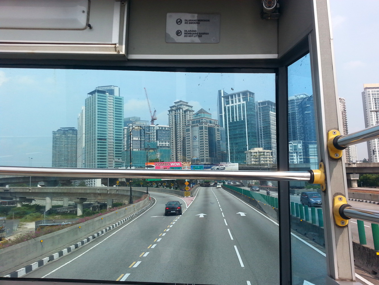 Tall buildings and overpasses as seen from the top of a hop on hop off bus