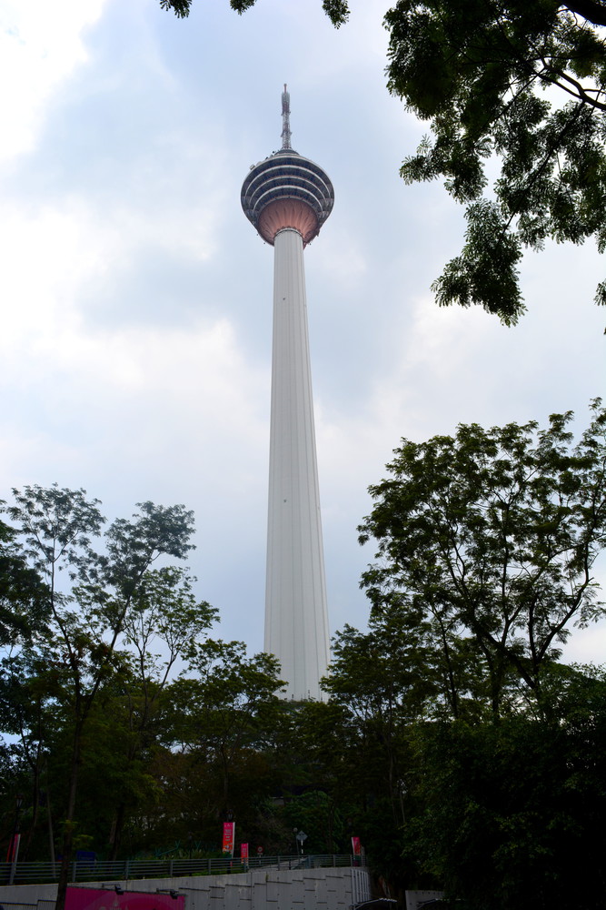 Kuala Lumpur Tower standing tall, surrounded by shrubs and trees; the antenna of the tower reaches 421 metres (1381 feet) above the ground level
