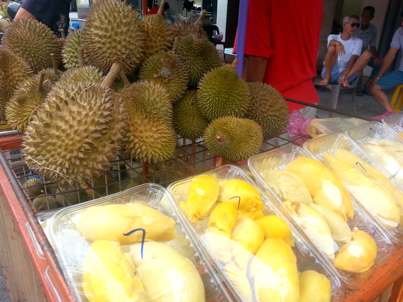 Whole and sliced durians for sale at a street side stall