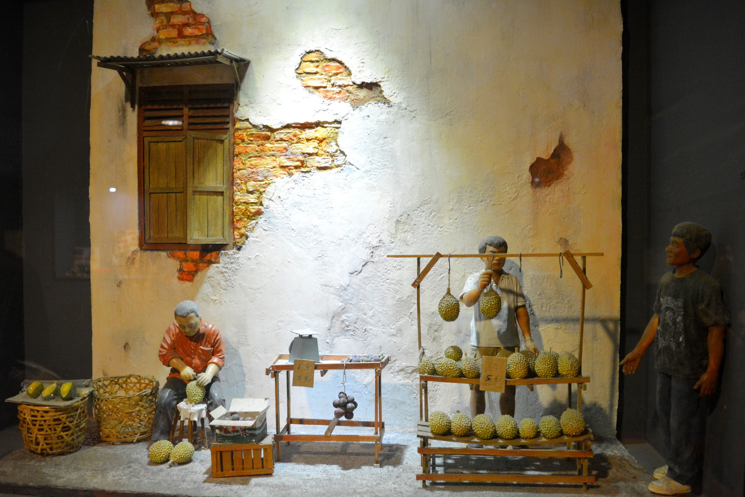 Miniature sculptures of men selling and slicing durians
