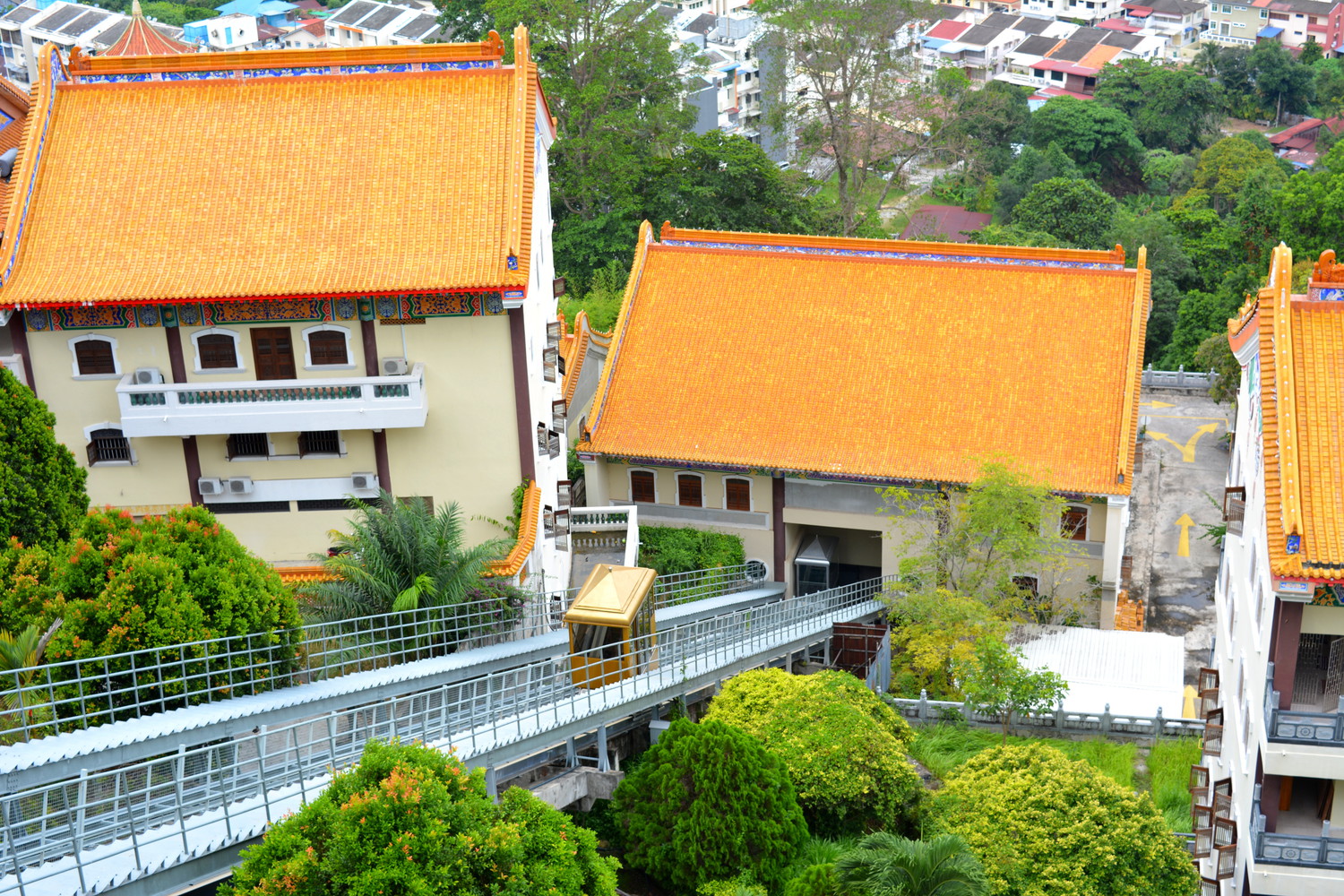 An inclined lift surrounded by buildings with bright yellow and orange tiles
