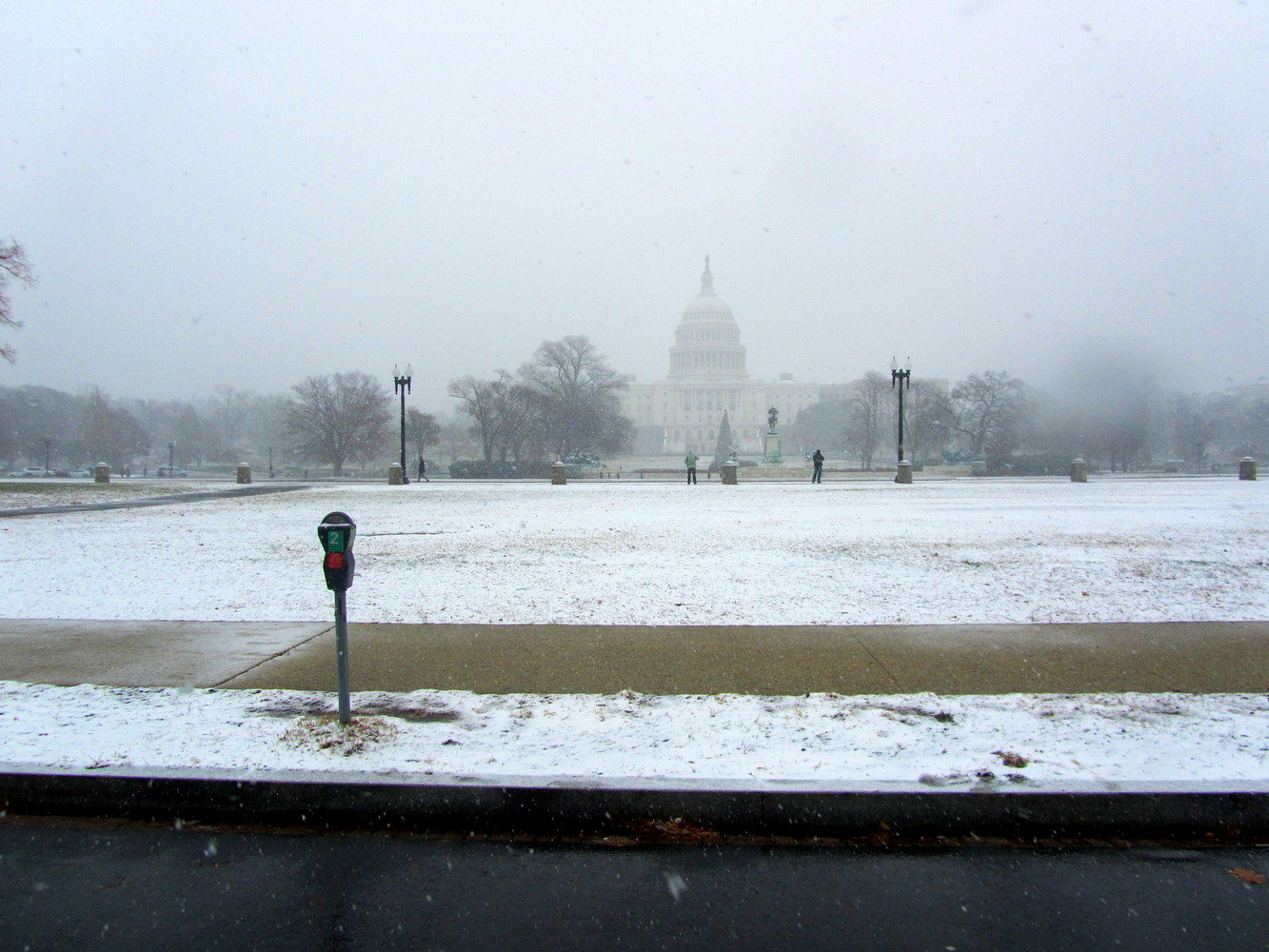 Ground covered in snow in front of United States Capitol during snowfall