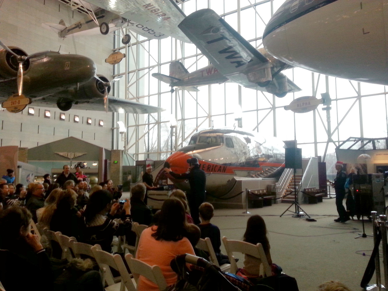 The US Navy Band playing musical instruments and performing in front of an audience at the National Air and Space Museum
